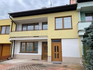 米库洛夫Pálava House Mikulov的黄色和白色的房子,设有棕色的门