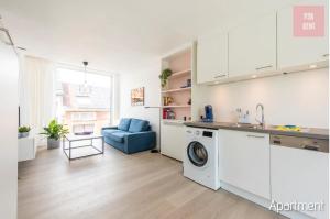 根特Lovely & Stylish accommodations at P36 Gent, near the Center的厨房配有洗衣机和蓝色沙发。
