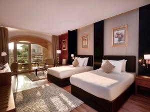 十月六日城Mövenpick Hotel Cairo - Media City的酒店客房带两张床和一个客厅
