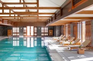 丽江丽江金茂凯悦臻选酒店的酒店游泳池设有躺椅和游泳池