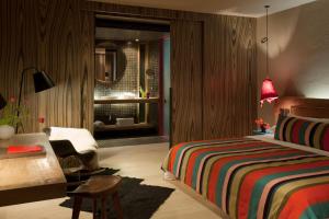 圣克里斯托瓦尔-德拉斯卡萨斯博酒店的一间卧室配有一张床、一张桌子和一把椅子