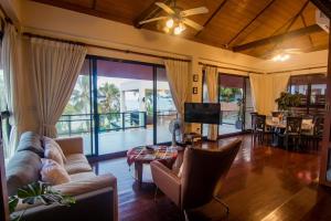 盼武里Baan SanSuk Pranburi - Beach Front & Pool Villa的带沙发和电视的客厅