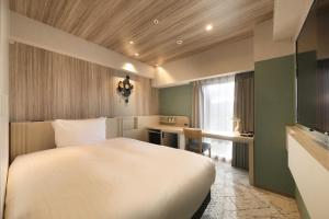 盛冈Richmond Hotel Morioka Ekimae的配有一张床和一张书桌的酒店客房