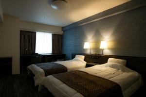 尾道市Sakura Hotel Onomichi Ekimae的酒店客房设有两张床和窗户。