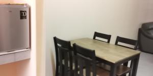 Kuala KeraiAqiza Home Kuala Krai的厨房配有桌椅和冰箱。