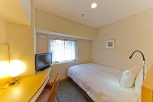鹿儿岛鹿儿岛日光酒店的酒店客房,配有床和电视