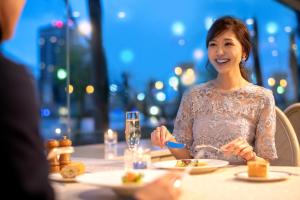 新泻新泻大酒店 的坐在餐桌上吃食物的女人