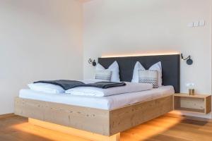 卡斯特尔罗托Aura Chalets - Nr 3的一间卧室配有一张大床和黑色床头板