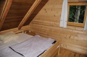 博希尼Gorska hiška Vogar nad Bohinjskim jezerom的小木屋内的一张床位,设有窗户