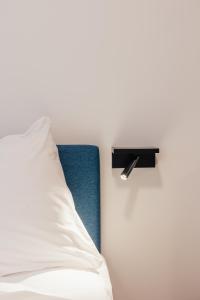 根特ROXI Residence Gent的一张带白色枕头和黑色架子的床