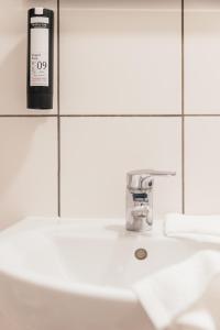根特ROXI Residence Gent的浴室水槽上方摆放着一瓶肥皂