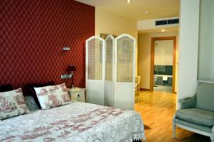 梅迪纳德里奥塞科Hospedium Hotel Vittoria Colonna的一间卧室设有一张床和红色的墙壁