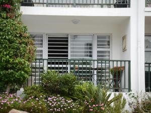 豪特湾dk villas 4 Riverview, Hout Bay的白色的房子,设有鲜花阳台