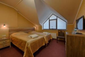 LesnikiHotel Riders Equides club的一间卧室设有两张床和窗户。