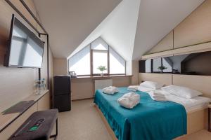 LesnikiHotel Riders Equides club的一间卧室配有一张带蓝色床单和窗户的床。