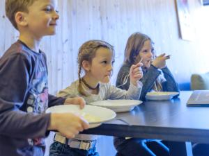 PassailAlmenland Apartment Passail的一群坐在桌子上吃食物的孩子