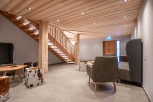沃瑟姆阿尔伯格Naturhaus am Arlberg的客房设有楼梯、椅子和一张床