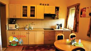 斯洛文尼亚格拉代茨罗兹卡公寓 的厨房配有白色橱柜、桌子和水槽。