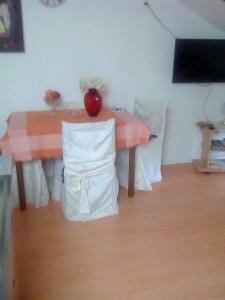 奥帕提亚Apartment Damir的一张桌子和椅子,上面有红色花瓶