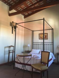 乌拉圭河畔康塞普西翁Posta Torreón的卧室配有一张床和一张桌子及椅子