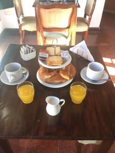 乌拉圭河畔康塞普西翁Posta Torreón的一张桌子,上面放着一盘食物和橙汁