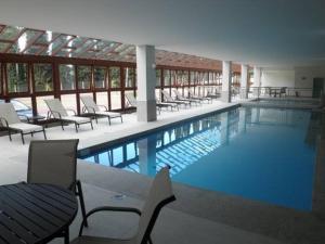 佩德拉阿祖尔Vista Azul的一个带躺椅和桌子的大型游泳池