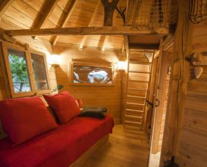 圣迪耶Parthénope - Les Cabanes du Chêne Rouvre的小屋内的小房间,配有红色沙发