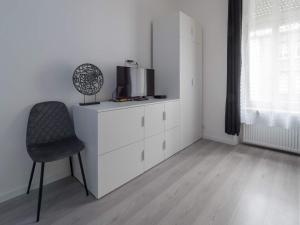 卢森堡EXECUTIVE SINGLE ROOM WITH EN-SUITE in GUEST HOUSE CITY CENTRE的客厅配有椅子和梳妆台上的电视