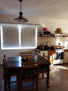里奥塞瓦约斯Casita de las Sierras的厨房配有一张桌子,上面放着一碗水果