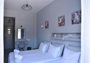 纳乌萨Liprando的卧室配有白色的床和白色枕头。