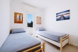 莱乌卡Casa Boarni Leuca的带窗户的客房内设有两张单人床。