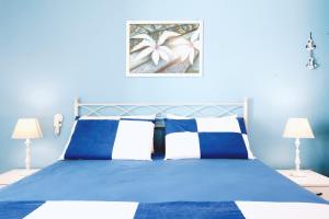 莱乌卡Casa Boarni Leuca的蓝色卧室配有蓝色的床和两盏灯