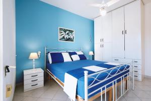 莱乌卡Casa Boarni Leuca的蓝色的卧室,配有床和蓝色的墙壁