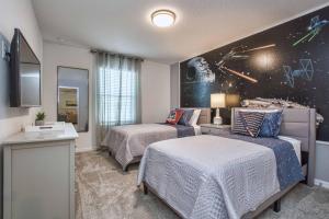 奥兰多5 Bedrooms Townhome w- Splashpool - 8205SA的一间卧室设有两张床和空间主题的墙壁。