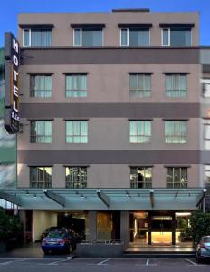 新山YANGTZE HOTEL 长江酒店的一座大型建筑,前面有汽车停放