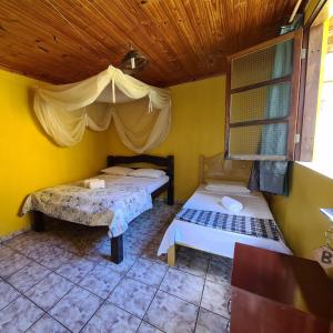 韦尔卡鲍Casa da Trilha的一间卧室设有两张床和木制天花板