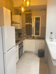突尼斯Zayatine RDC的厨房配有白色橱柜和白色冰箱。