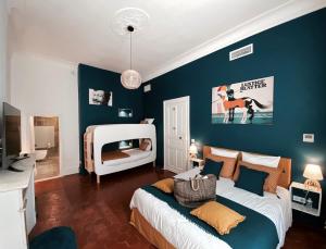 MontbazinLa Domitia - Maison d'hôtes, spa & massages的卧室配有白色的床和蓝色的墙壁