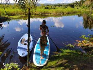 喀巴里特Room in Lodge - Method Living Tropical Edition的两个男孩站在水中的桨板上