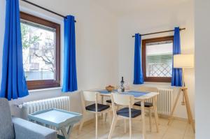博尔扎诺Peters Guest House的一间设有蓝色窗帘和桌椅的用餐室