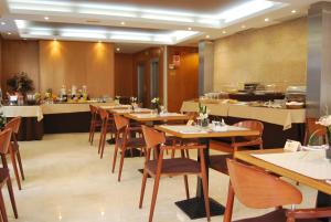 瓦伦西亚Hotel RH Sorolla Centro的一间设有木桌和椅子的餐厅以及自助餐