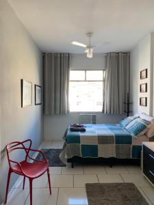 里约热内卢Copa apt°/ 1Qd da Praia bela vista的一间卧室配有一张床和一张红色椅子