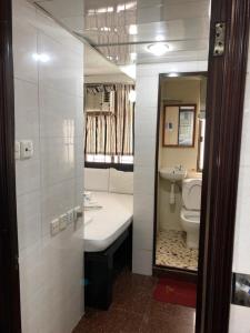 香港Crystal Hostel的一间带卫生间、水槽和镜子的浴室