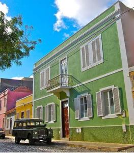 明德卢Casa Colonial的停在绿色建筑前面的吉普车