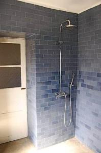 明德卢Casa Colonial的带淋浴的浴室和蓝色砖墙