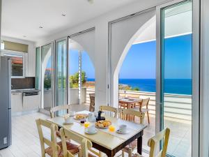 卡拉塔斯Villa Anemos by Estia的一间设有桌子的海景用餐室