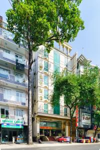 胡志明市Lam Kinh Hotel的前面有树木的高楼