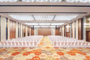 长沙长沙会展诺富特酒店的空空的大厅,配有白色的椅子和木墙