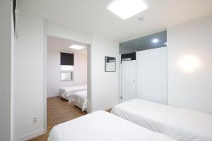 釜山Ekonomy Haeundae Hostel的一间卧室配有两张床和镜子