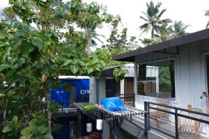 庞岸达兰Hau Eco Lodges Citumang Pangandaran的有一个门廊,上面有蓝色的枕头
